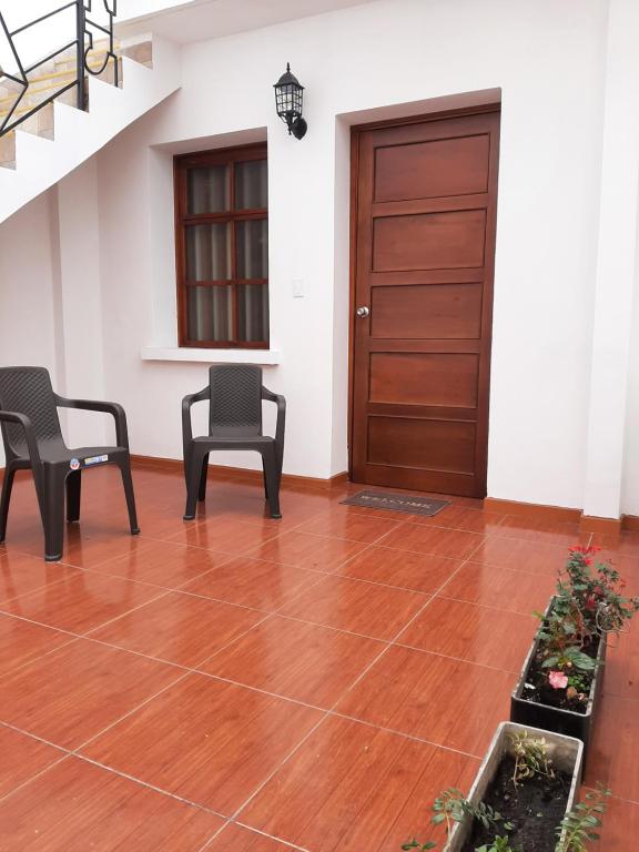 a room with two chairs and a wooden door at Casona Feran in Pasto