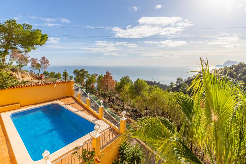 an outdoor swimming pool on top of a house with the ocean at Macondo Altea Hills in Altea