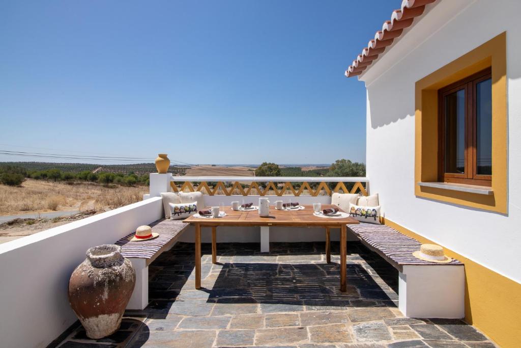 a patio with a table and chairs on a balcony at Casas do Monte I - T2 in Mértola