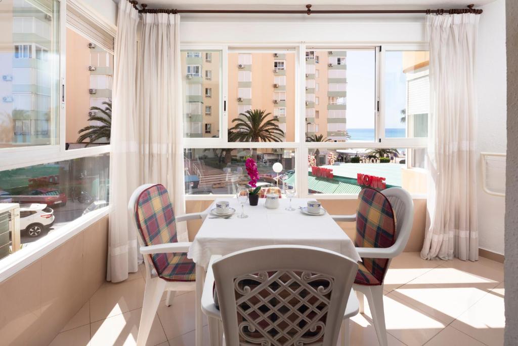 a dining room with a table and chairs and a window at Estudio Bloque 89 in Torrox