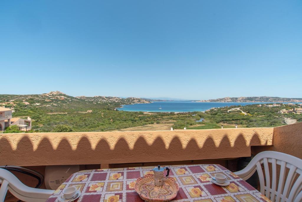 a table on a balcony with a view of the ocean at Flat Orizzonte in Palau