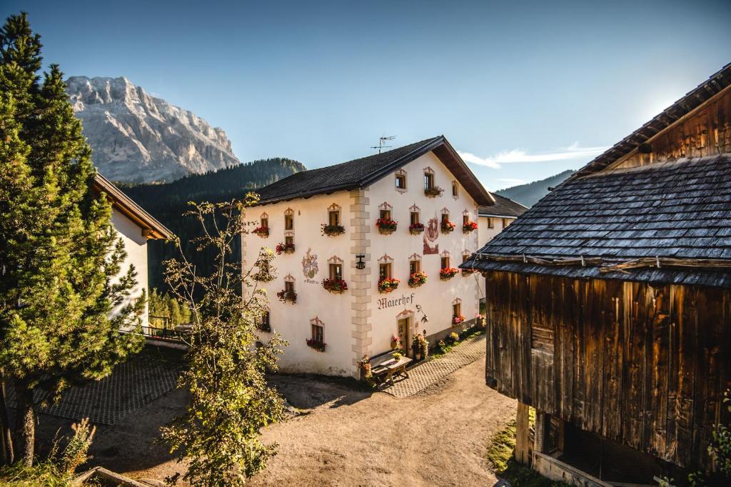 Ein großes weißes Gebäude vor einem Berg im Hintergrund in der Unterkunft Maierhof in Wengen