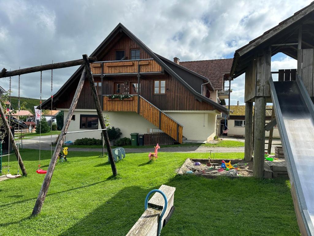 a playground in front of a house with kids playing at Obsthof Mainberger in Kressbronn am Bodensee