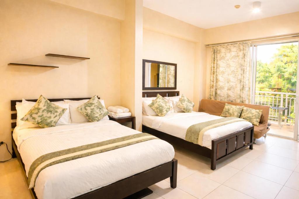 a hotel room with two beds and a window at Nade Suites - Pico De Loro MIB 601 in Nasugbu