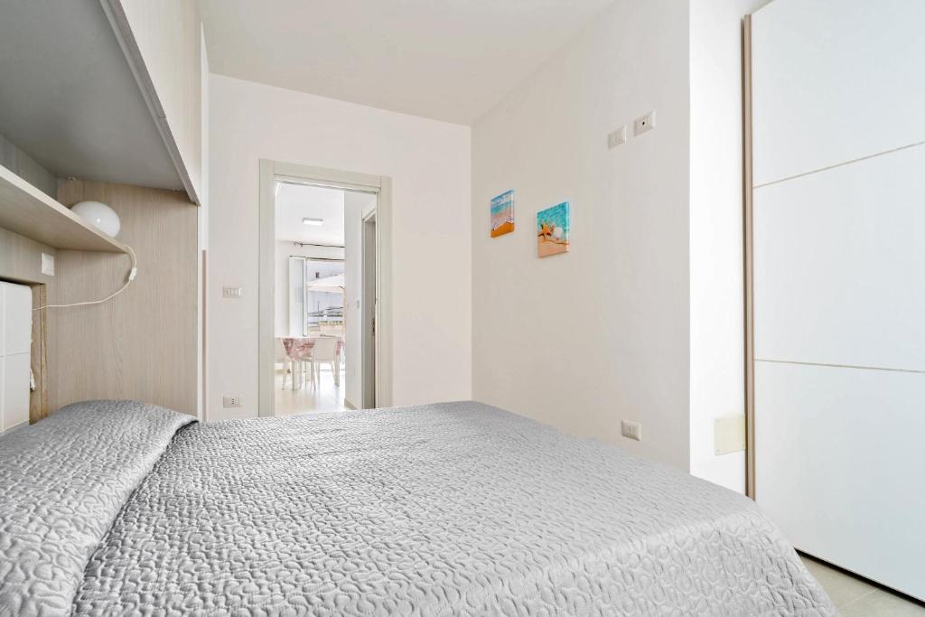 a white bedroom with a bed and a closet at Casa d'a mare in Torre San Giovanni Ugento