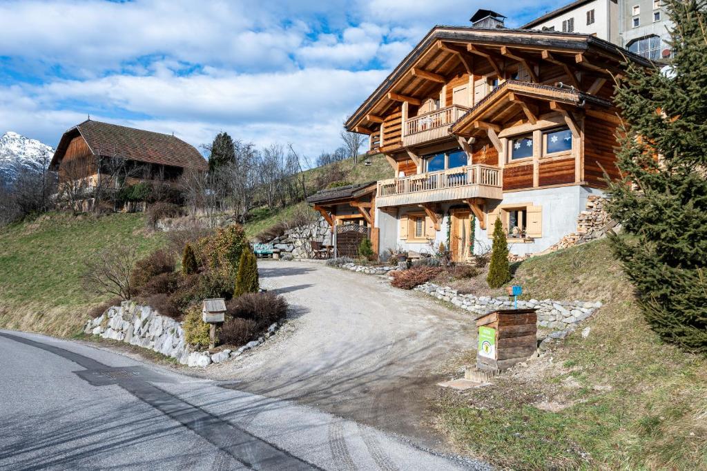 a large wooden house on the side of a mountain at Tié No Appartement Chaleureux in Manigod