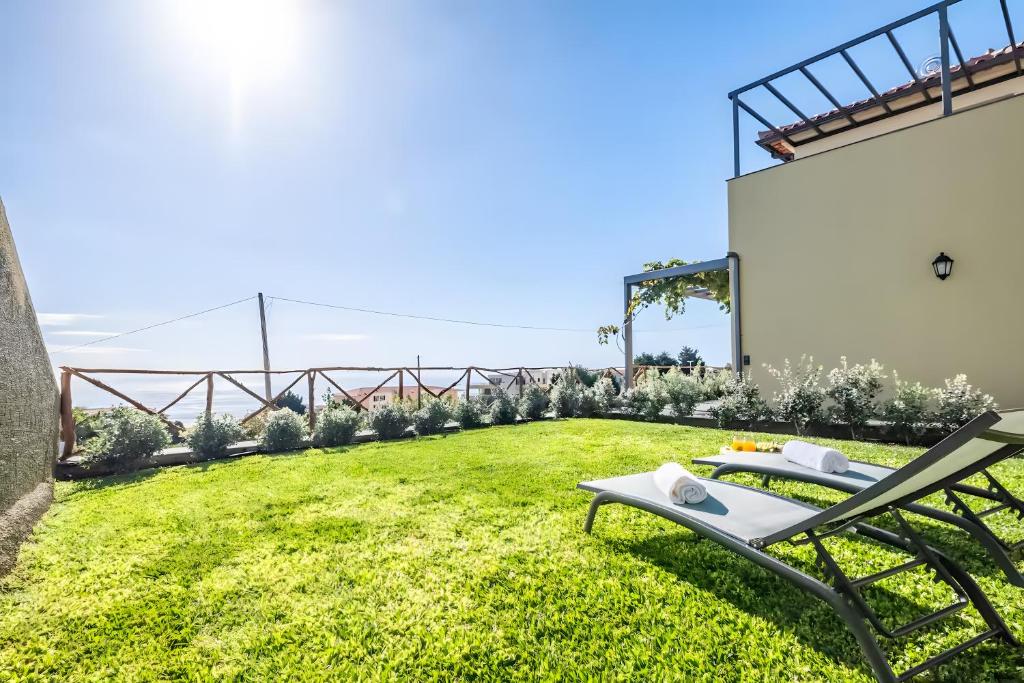 a garden with a chaise lounge on the grass at Ocean View Apartments in Caniço