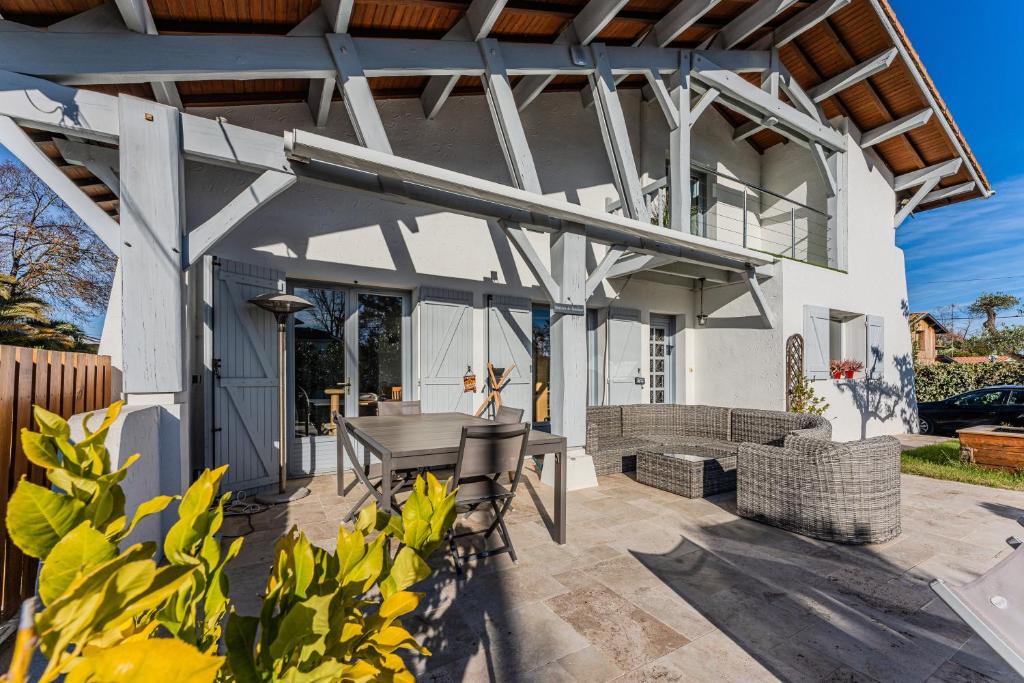 an outdoor patio with a table and chairs at Chambre D'hote Chez Amaya in Gujan-Mestras