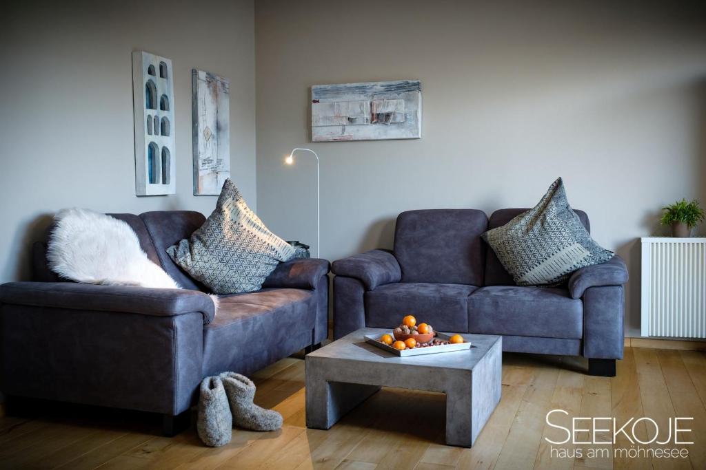 a living room with two couches and a coffee table at Seekoje - Haus Am Möhnesee in Möhnesee