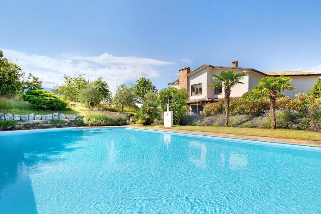 a large blue swimming pool in front of a house at Apartment Jose in Tremosine Sul Garda