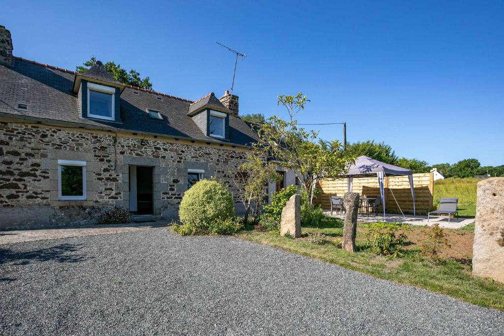a stone house with a gravel driveway in front of it at Maison de vacances Kerkohann in Tressignaux