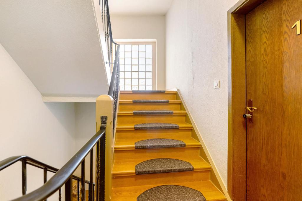 a stairwell with wooden steps and a door at Gästezimmer St Wendel in Prüm