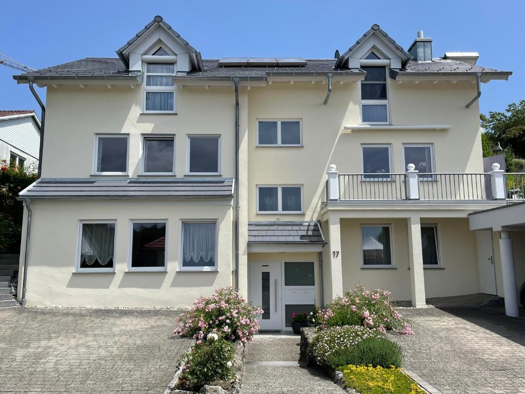 a large white house with a balcony at Ferienwohnung Nell in Daisendorf