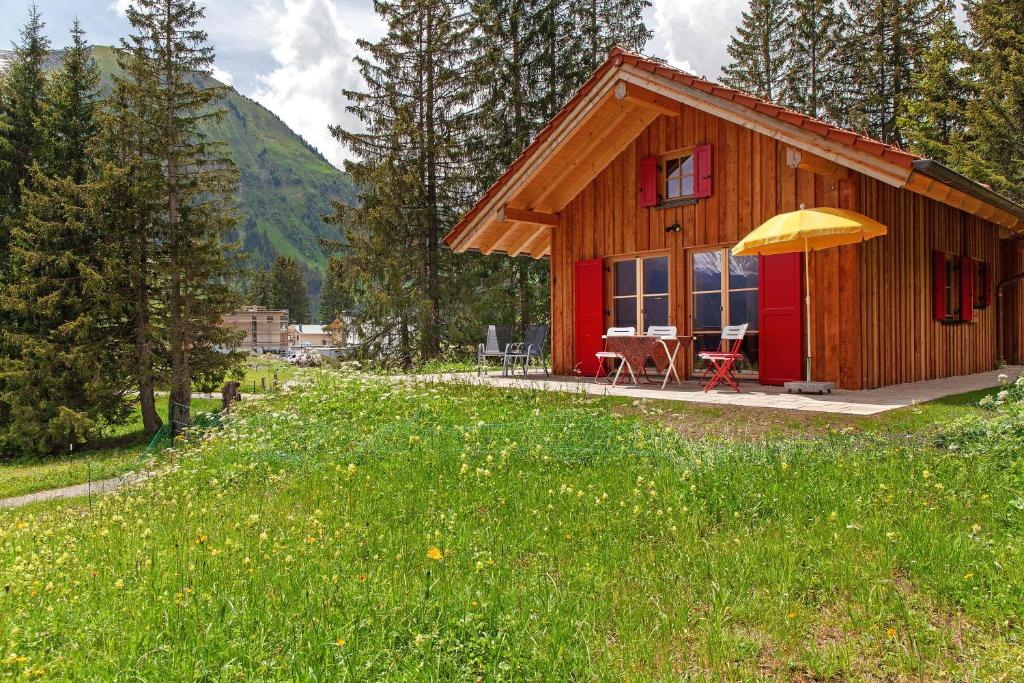 a small cabin with a yellow umbrella in a field at Chalet87 in Berwang