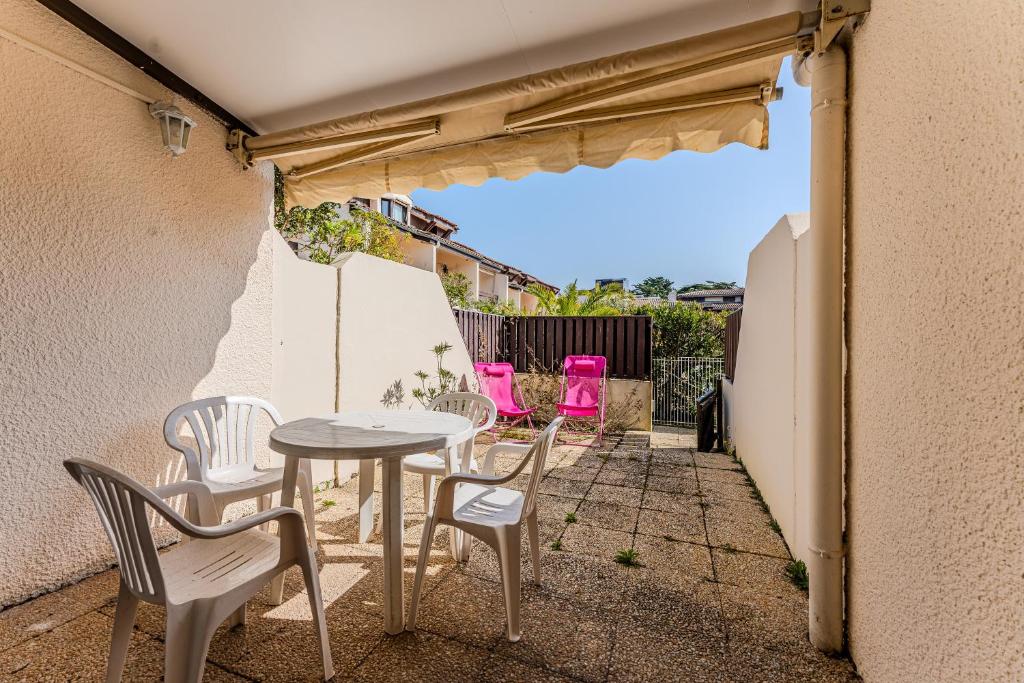 a patio with a table and four chairs at La Forestière Cap Ferret - Réf 2 in Lège-Cap-Ferret