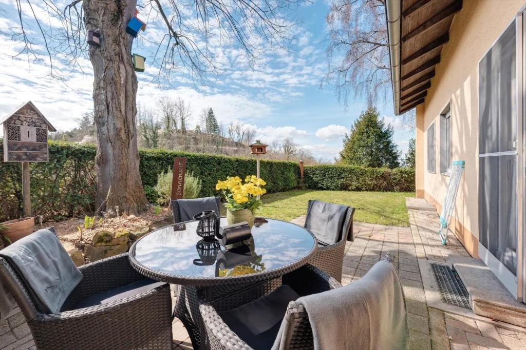 a patio with a table and chairs and a tree at Baumschule Rombach - 'Spatzennest' in Herbolzheim