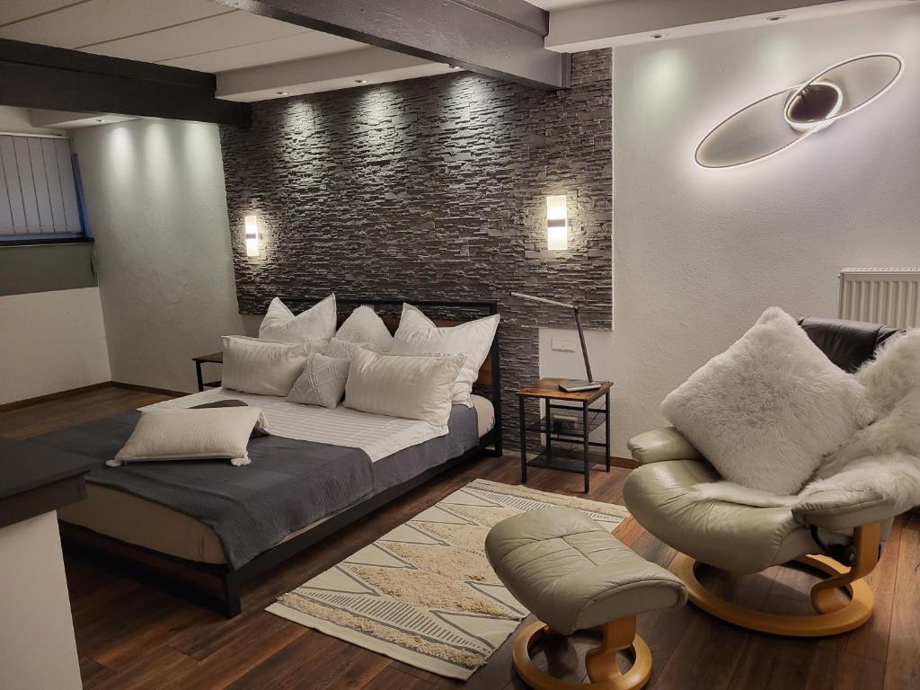 a living room with a bed and a chair at Hainberg-Loft mit Gartensauna in Mellrichstadt