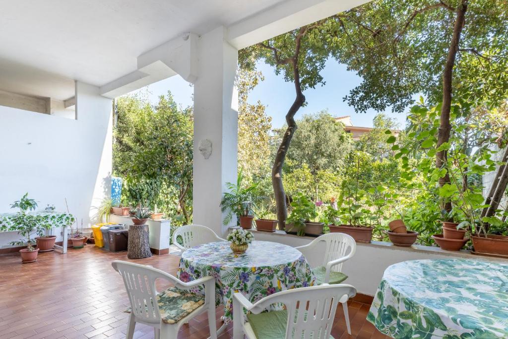 a patio with a table and chairs and trees at Sartiglia Domu in Oristano
