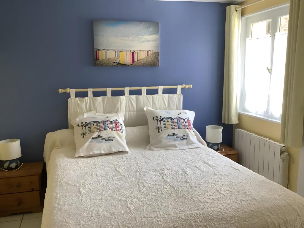 a bedroom with a bed with two pillows on it at Chambres Paysannes Lecarpentier - in Fontenay