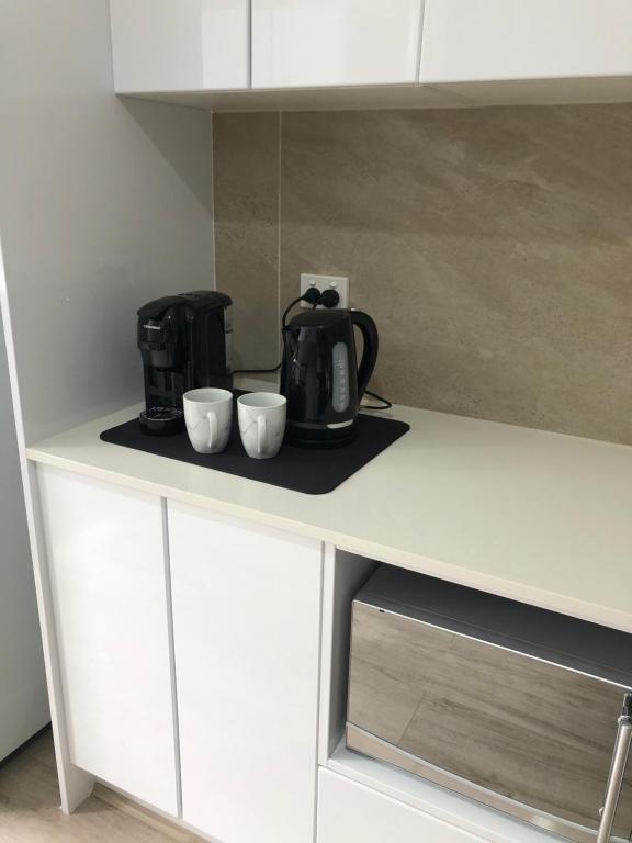 a kitchen counter with a coffee maker and two cups at Garlin Corner in Leggs Island