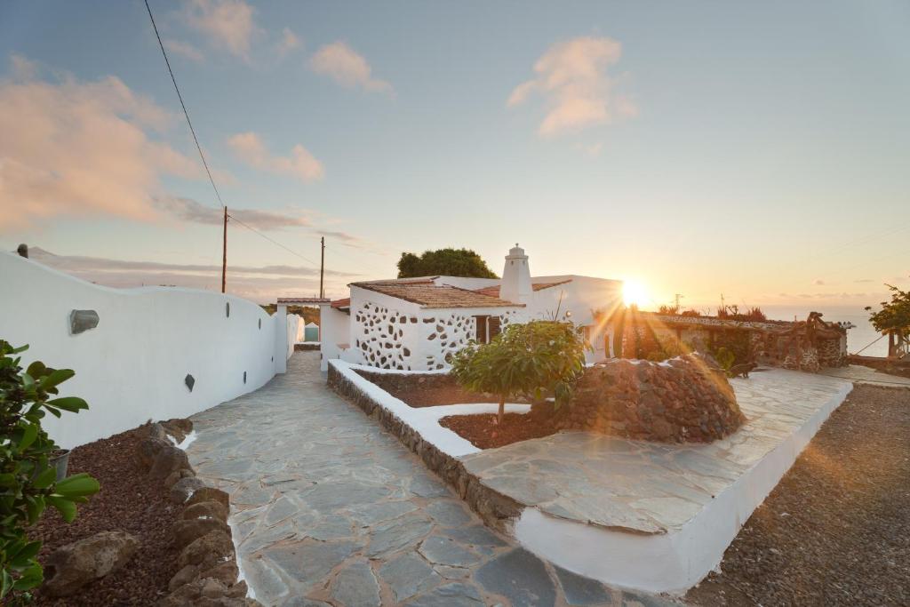 a view of a building with the sunset in the background at Espacio vivo Pisaverde in Tacoronte