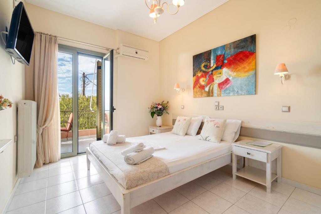 a bedroom with a bed and a large window at Nontas Home 23 in Kalamitsi