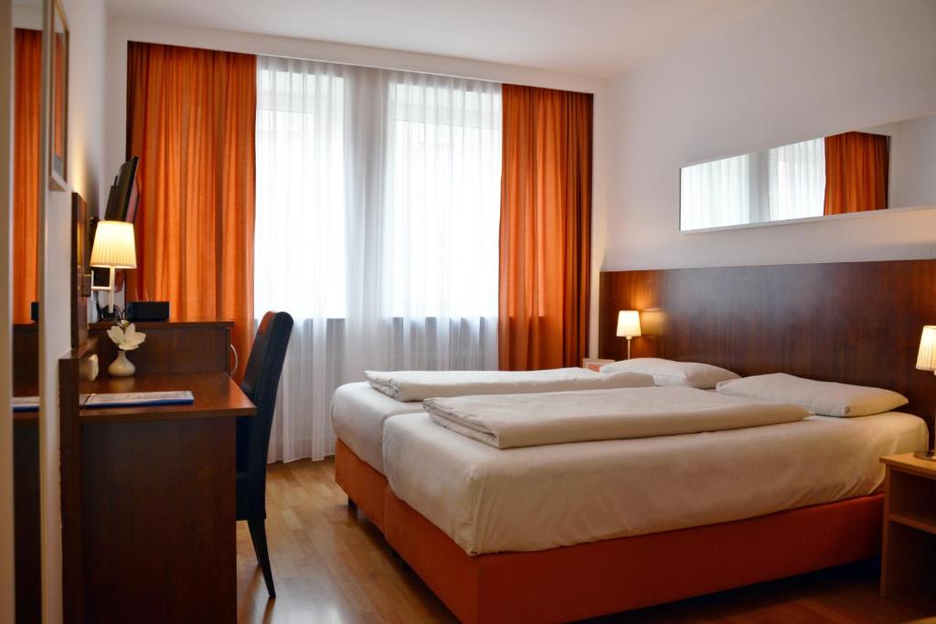 a hotel room with a large bed and a large window at Hotel Italia in Munich