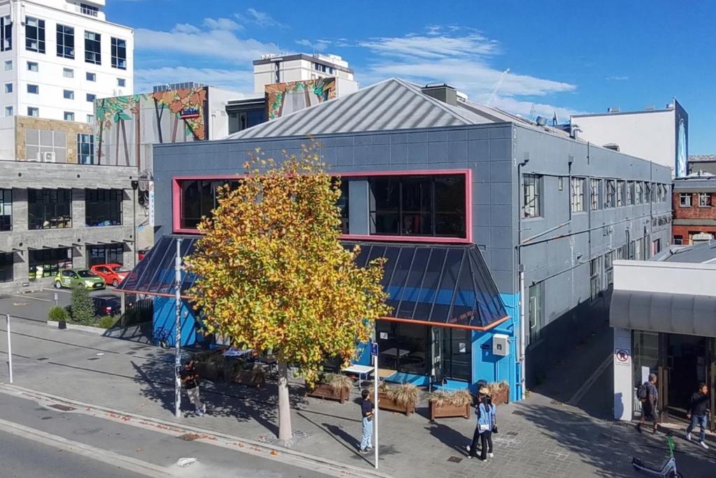 a building with a tree in the middle of a street at Urbanz in Christchurch