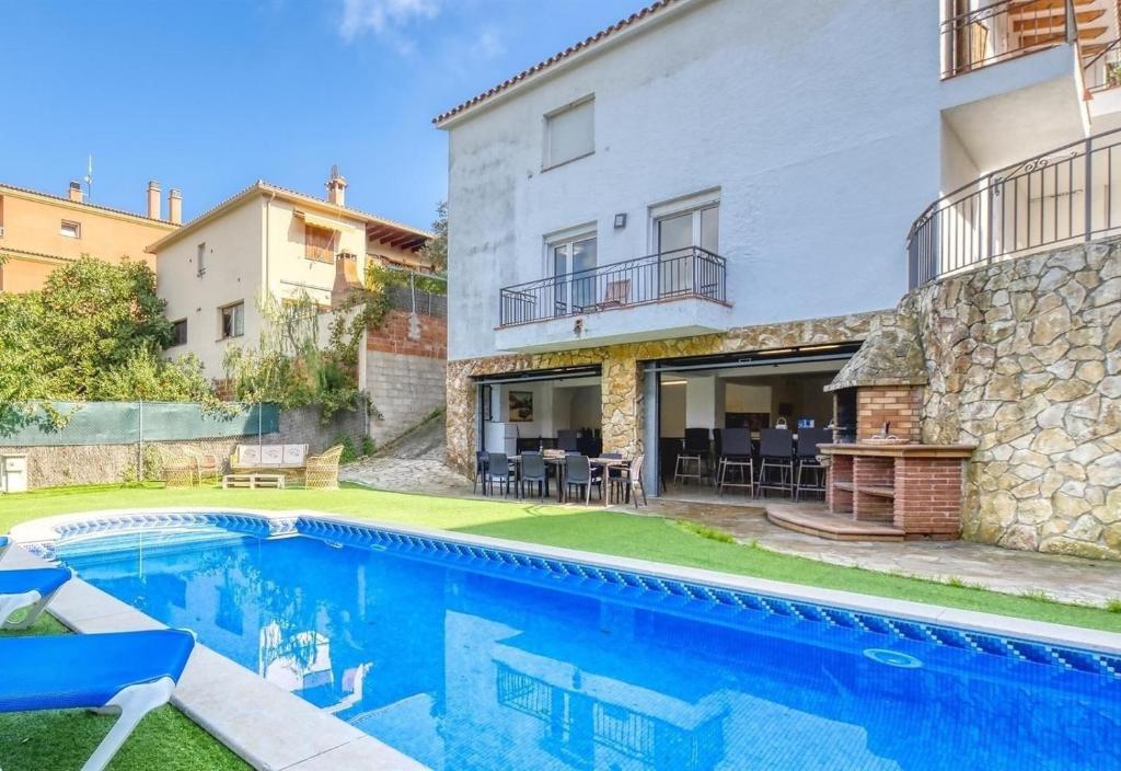 a villa with a swimming pool and a building at Costacabana - Villa Nicky in Lloret de Mar