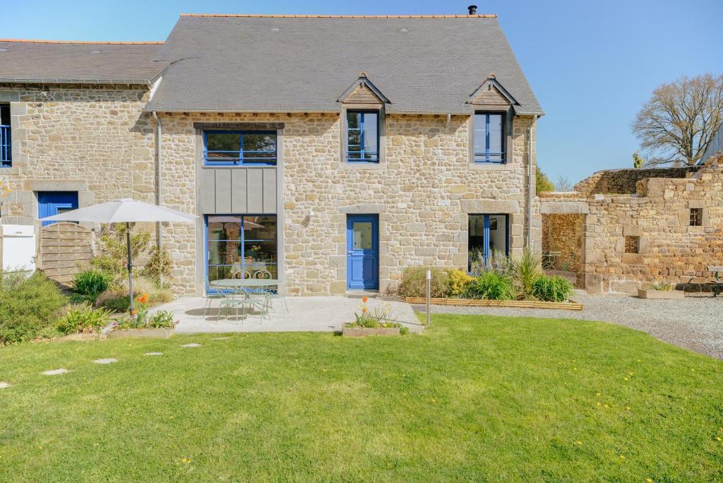 a brick house with a lawn in front of it at La ferme d'Alcide in Québriac