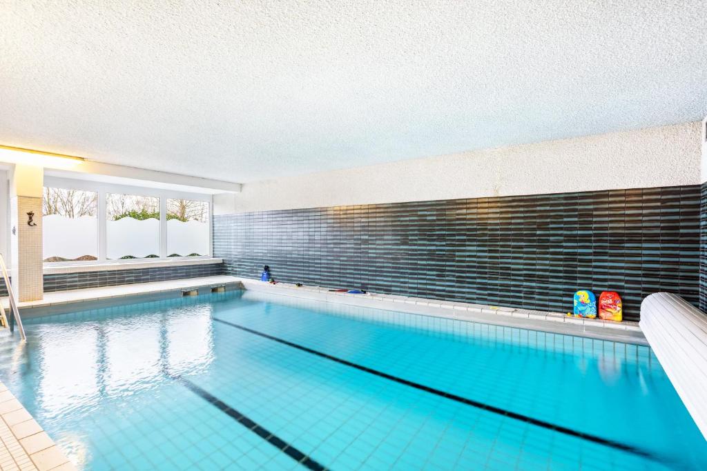 a large swimming pool with blue water at Ferienappartement Möhnesee mit Pool in Möhnesee