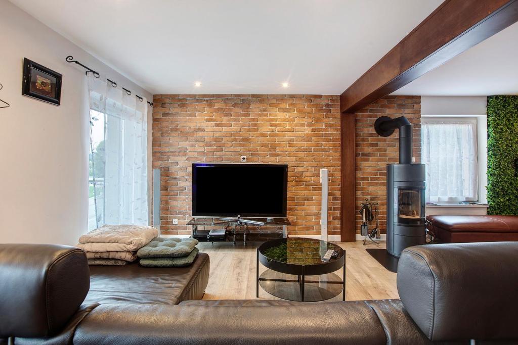 a living room with a couch and a television at Heimelige Schwarzwaldwohnung Wald in Häusern