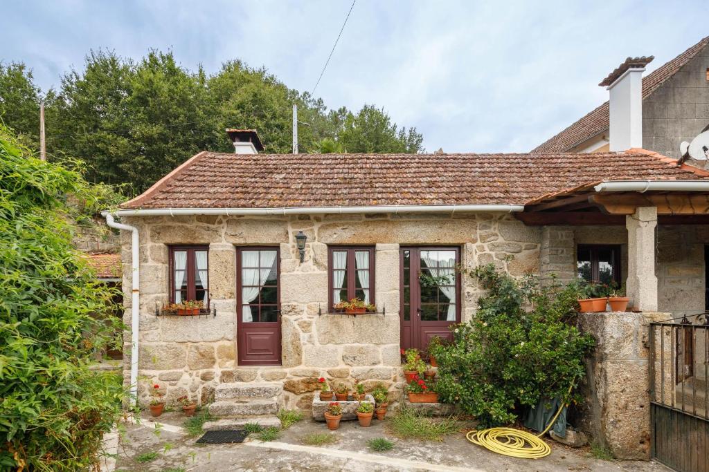 a small stone house with a red door at C Vilamide in Parada de Achas