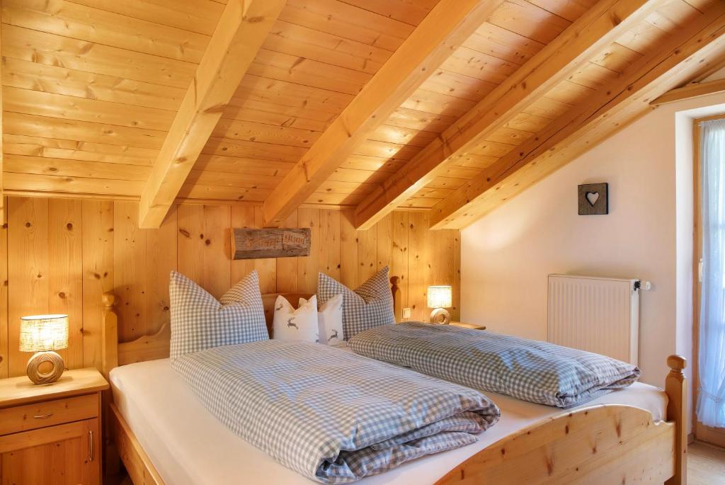 a bedroom with a bed in a room with wooden ceilings at Ferienwohnung Bergkristall in Grainau