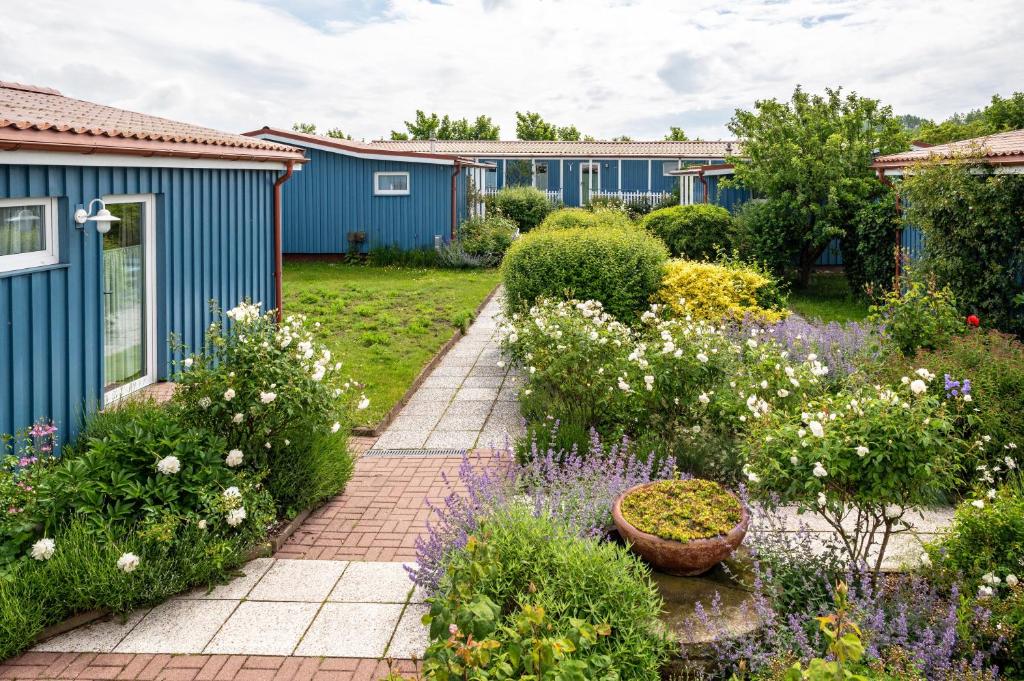 a garden with blue houses and flowers at Möve Aba Appartment 22 in Rerik