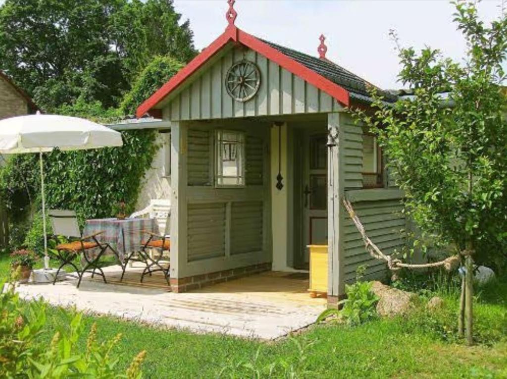 a small green cottage with a red roof at Charlottes Landlust in Ribnitz-Damgarten