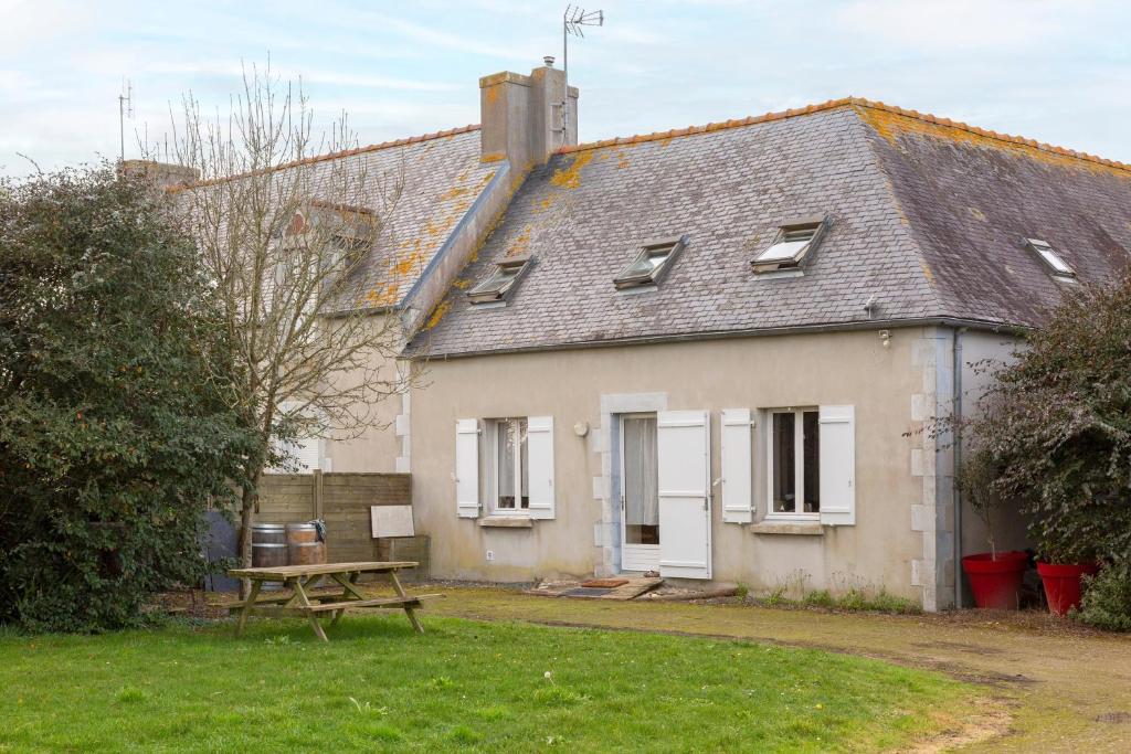 a house with a picnic table in front of it at Gite Terre Mer Des Sables Blancs in Plobannalec-Lesconil