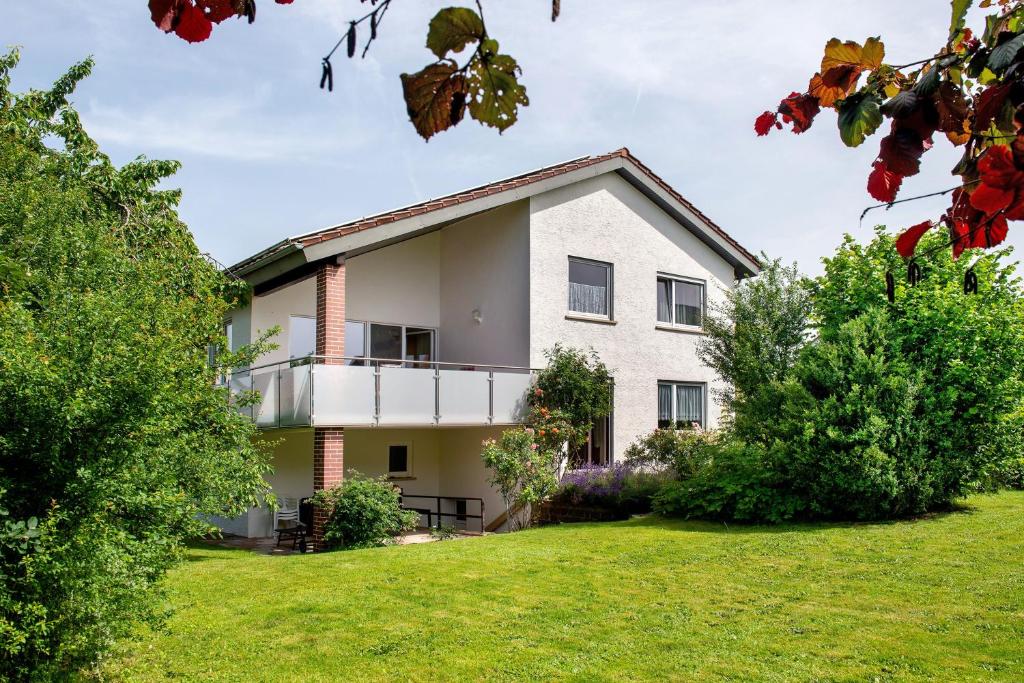 a white house with a balcony on a lawn at Ferienhaus Christine Bodensee Nord in Pfullendorf