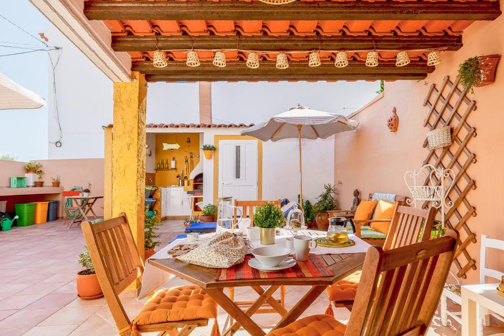 a dining room with a table and an umbrella at Sossego Alentejano in Reguengos de Monsaraz