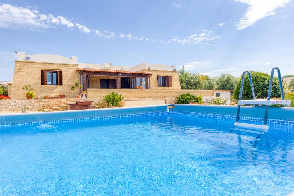 a swimming pool in front of a house at Villa Marilor in Salve