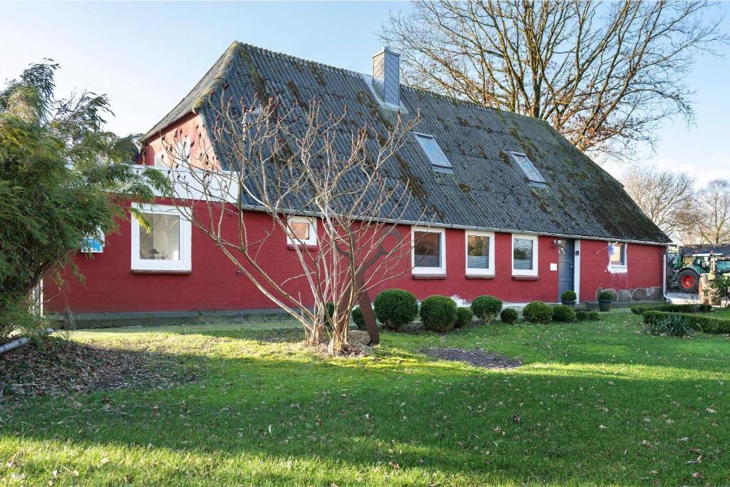 ein rotes Haus mit einem Mansarddach in der Unterkunft Room 24 in Behrendorf