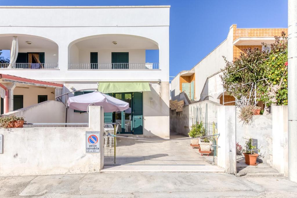 a street with a white building with an umbrella at Il Girasole in Torre Vado