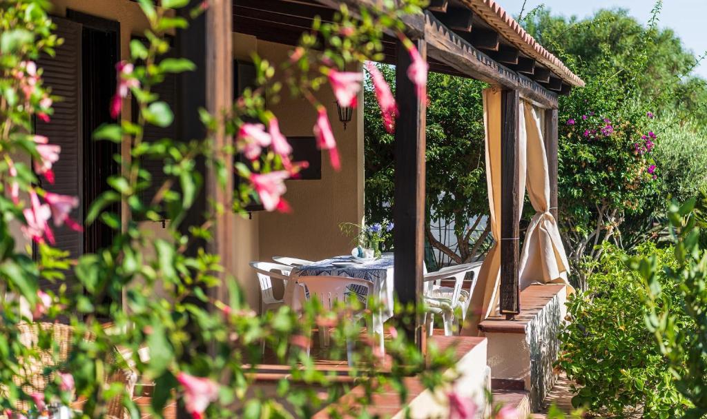 a table and chairs on the porch of a house at Villa Lucia in Costa Rei