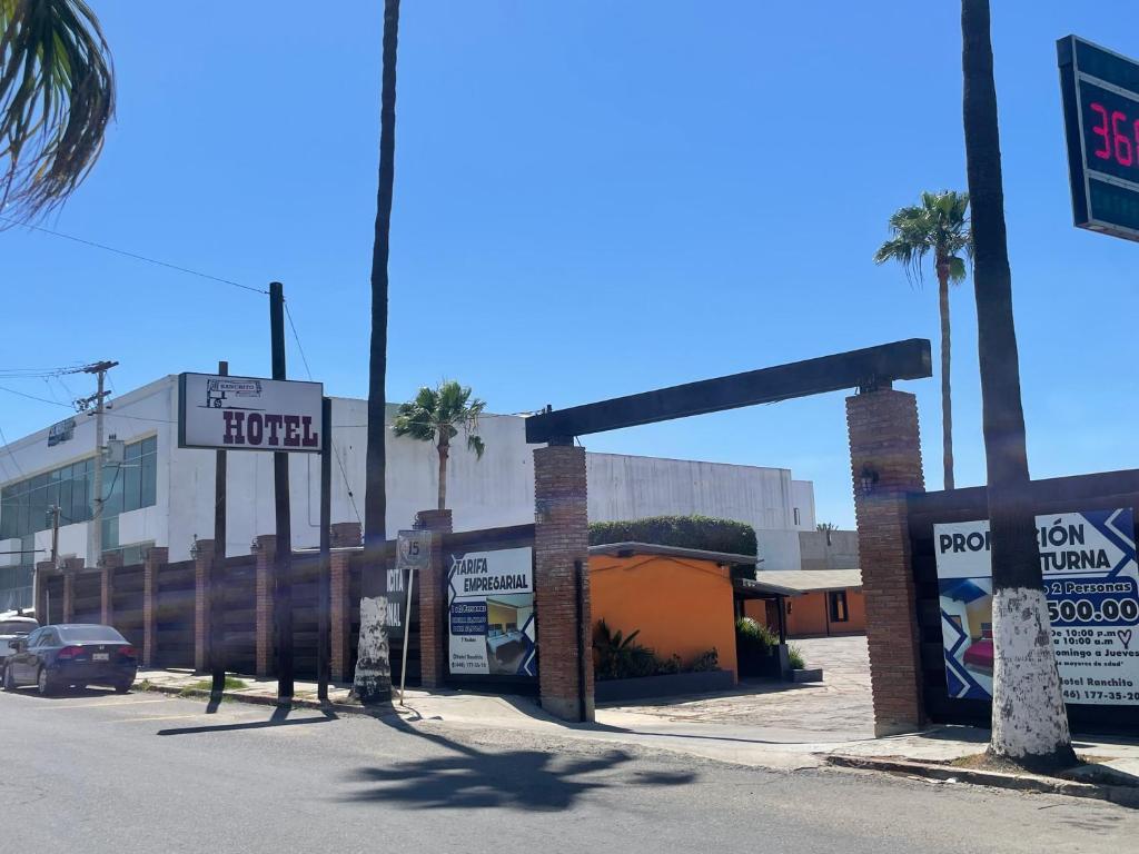 a parking lot with a hotel sign and palm trees at Hotel Ranchito in Ensenada