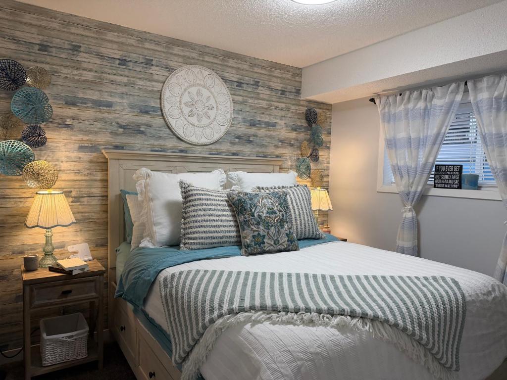 a bedroom with a bed and a wooden wall at Harrison Lakeside Retreat in Harrison Hot Springs