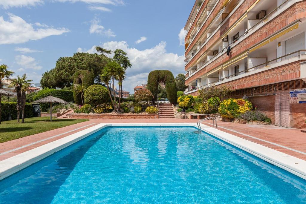 a swimming pool in front of a building at Fada Lloret in Lloret de Mar