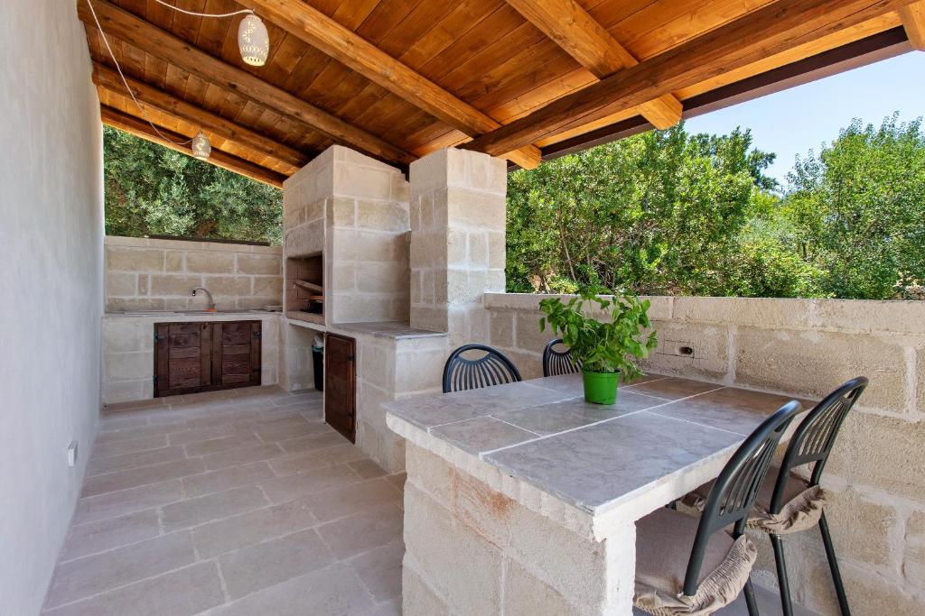 an outdoor kitchen with a table and chairs on a patio at Trulli House in Putignano