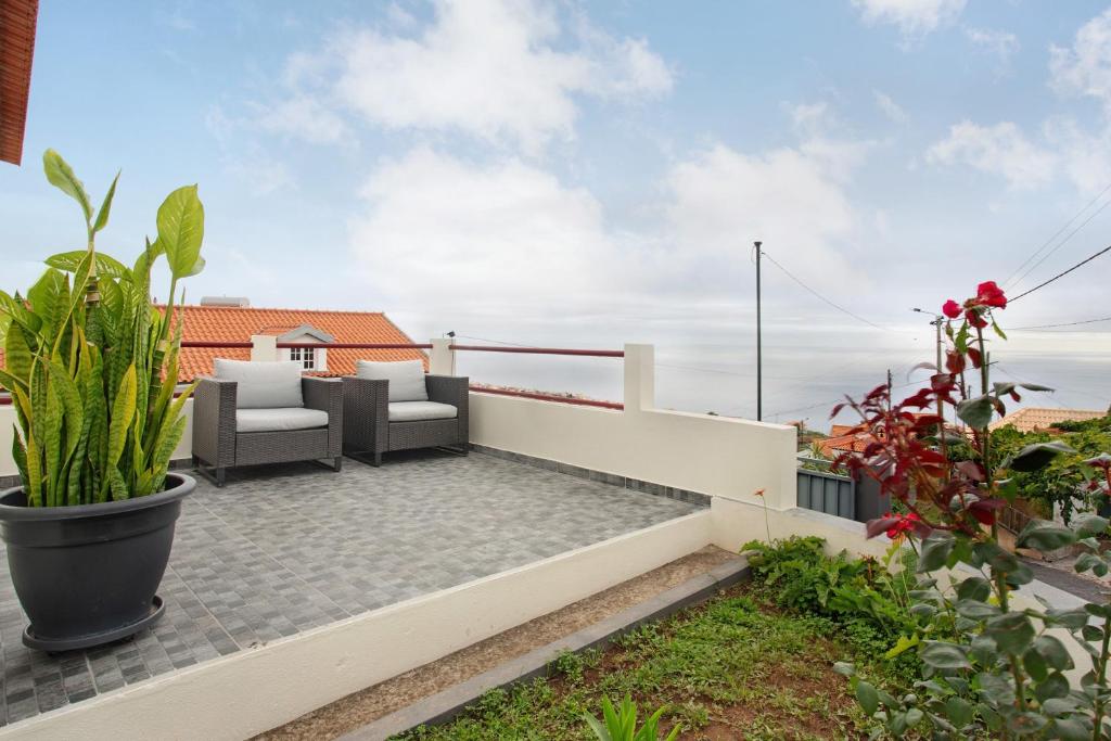 eine Terrasse mit Möbeln und Pflanzen auf einem Dach in der Unterkunft Simão House in Calheta