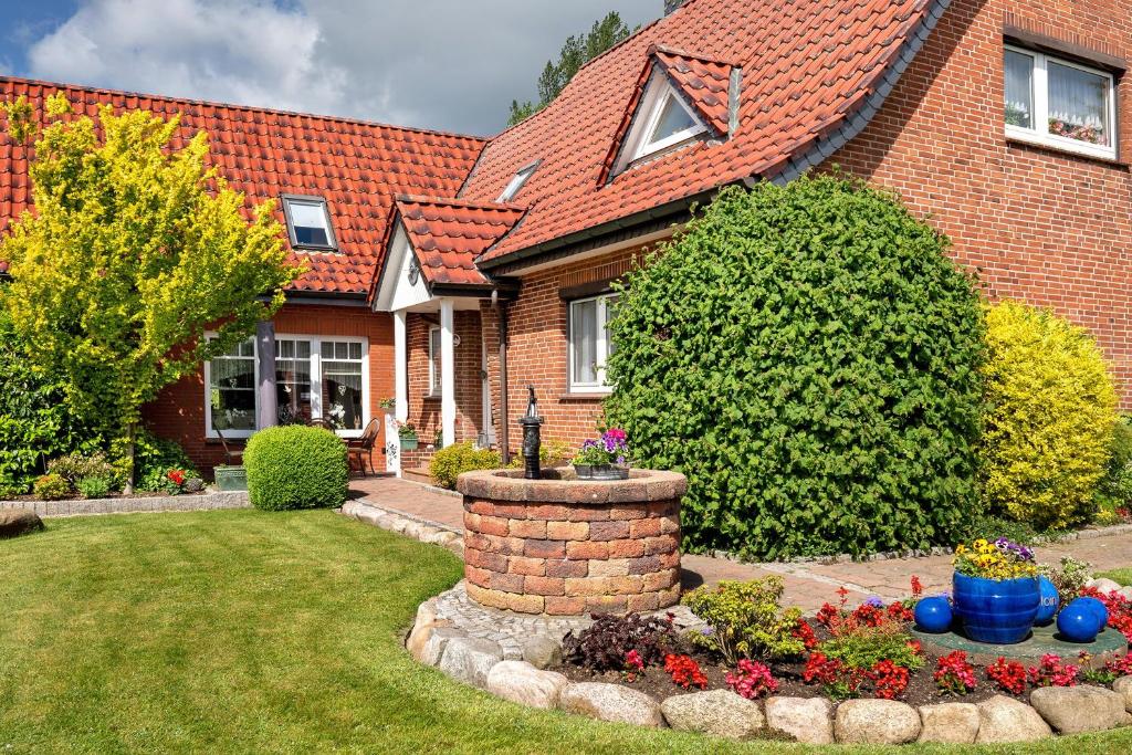 a brick house with a brick fountain in the yard at Ferienwohnung Simonsen in Rabenkirchen-Faulück