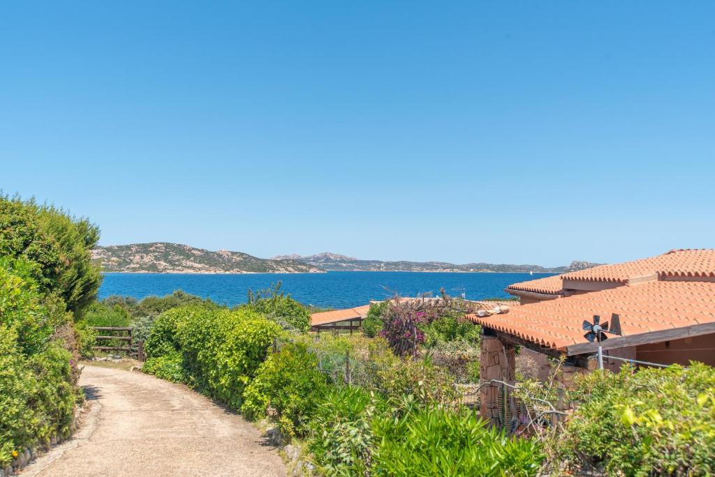a dirt road next to a house and the ocean at House Punta Nera in Palau